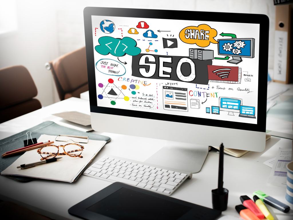Computador sobre mesa de escritório com ilustrações de SEO